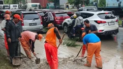 Petugas PPSU Kelurahan Cilincing Bersihkan Lumpur di Jalan Raya Akses Marunda.