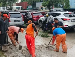 Petugas PPSU Kelurahan Cilincing Bersihkan Lumpur di Jalan Raya Akses Marunda.
